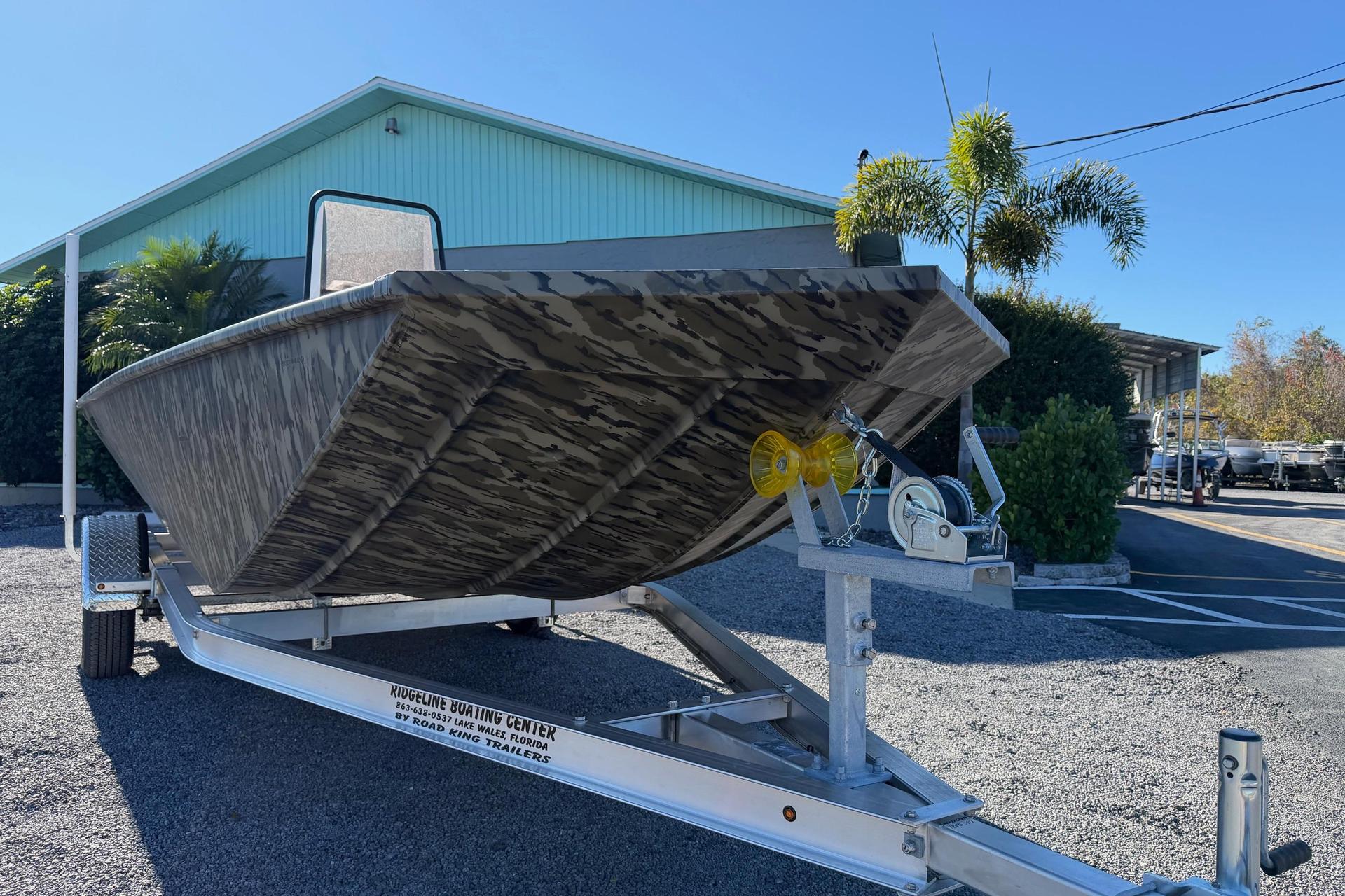 2026 Smoker Craft Sportsman 1866 boat on trailer, camo design, outdoor setting.